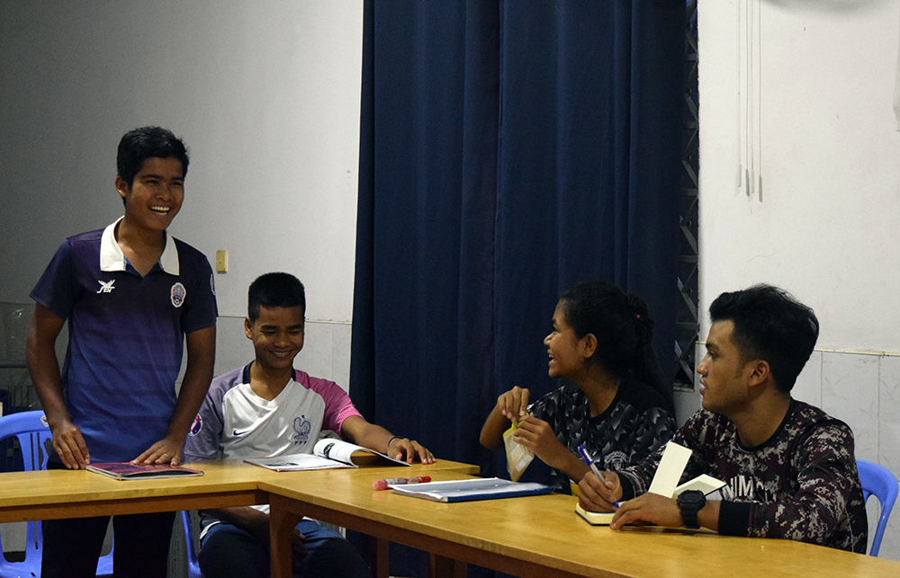 Chamnab smiles as he answers a question during English class at the dormitory