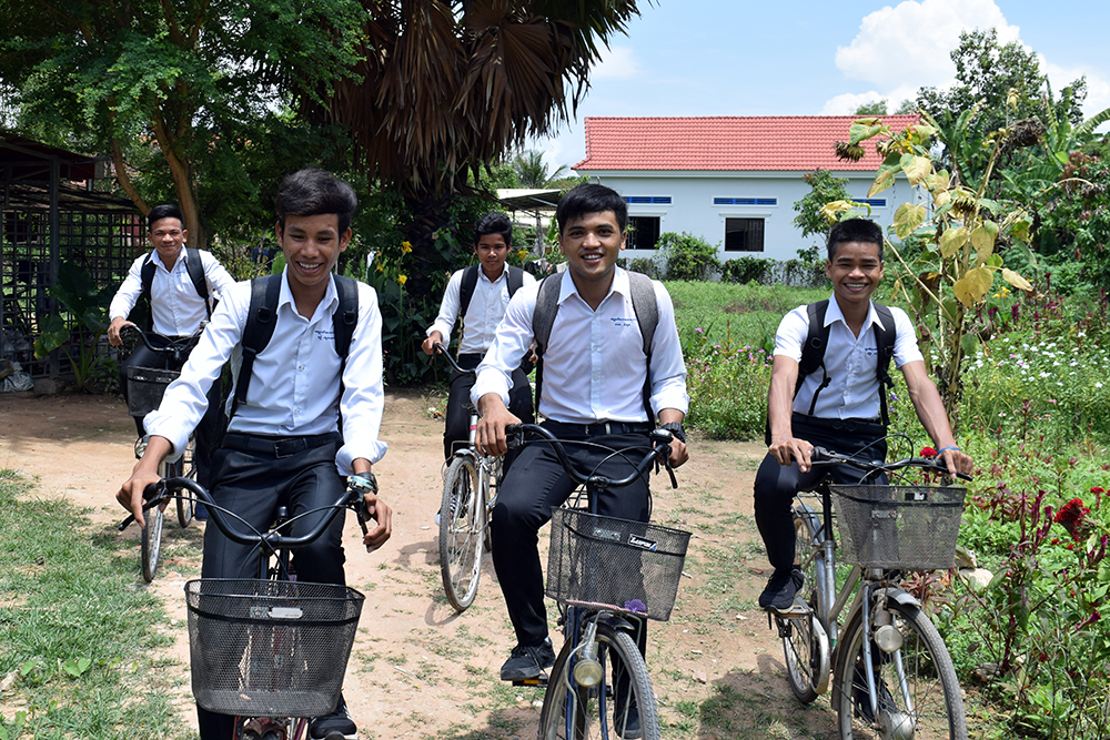 from left, Thik, Chan, Chamnab, Ravuth, and Non smile as they head out on their bicycles to classes
