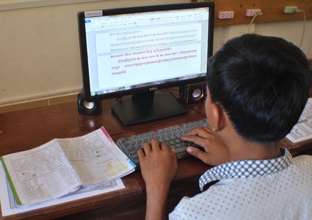Student typing in Khmer